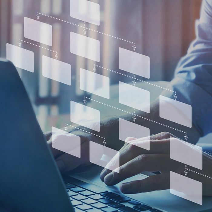 Person typing user flow diagram above keyboard